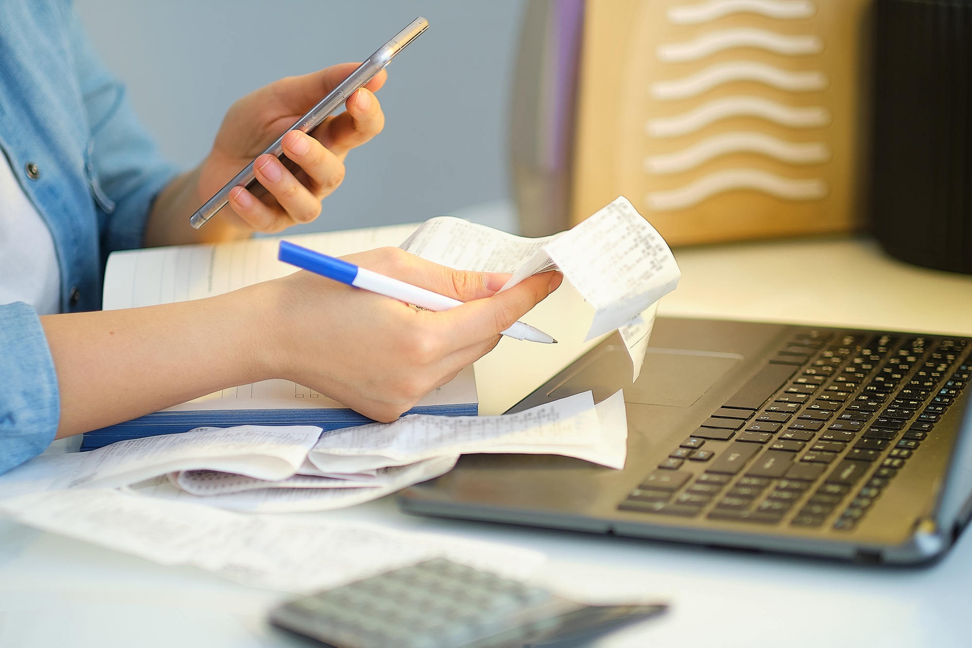 woman holding the bills to calculate in living room at home. Expenses, account, taxes, home budget